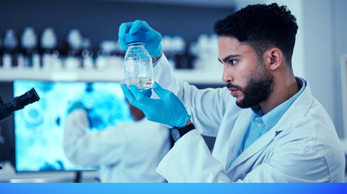 Scientist analyzing a clear water sample in a laboratory to test for hidden contaminants not visible to the eye